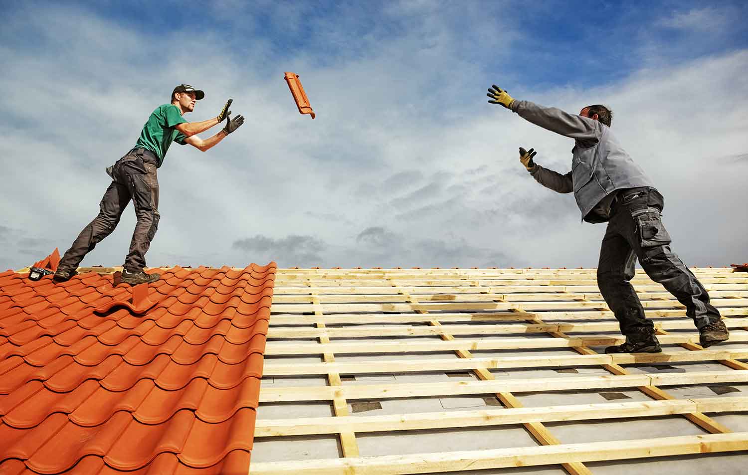 Kompetente Mitarbeiter der Dachdeckerfirma Valder Bedachungen aus Kreuzau arbeiten mit hochwertigen Materialien auf einem Dach in Düren.